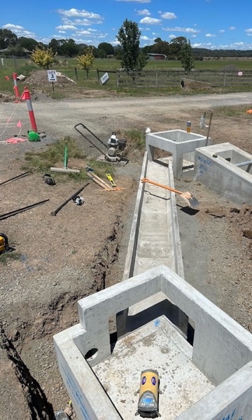 Precast concrete pits and a channel laid in an open trench on a rural site